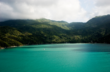 Lake surrounded by trees, with mountains in background
